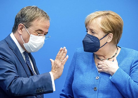Armin Laschet, candidate for chancellor of Germany's center-right block of the Christian Union parties speaks with Chancellor Angela Merkel. (Photo | AP)