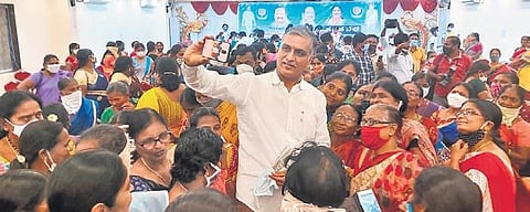 Finance Minister T Harish Rao takes a selfie with Anganwadi workers during a programme organised by the latter in Huzurabad on Sunday.