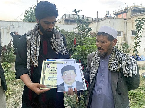Mohammed Jan Sultani's father, Ali, right, looks at his son's Taekwondo championship certificates along with picture of him. (Photo | AP)