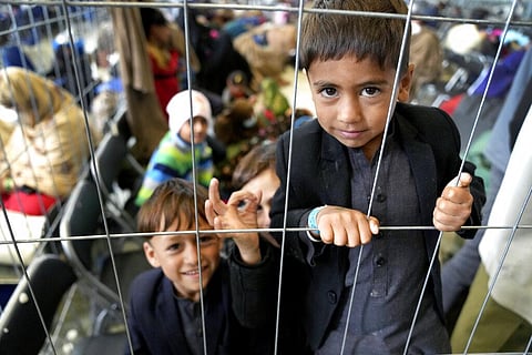 Kids stay behind a fence in a hangar as they wait for their departure at the Ramstein U.S. Air Base in Ramstein (Photo | AP)