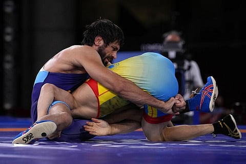 Kazakhstan's Nurislam Sanayev, bottom, and India's Kumar Ravi compete during the men's 57kg Freestyle semifinal wrestling match at the 2020 Summer Olympics. (Photo | AP)