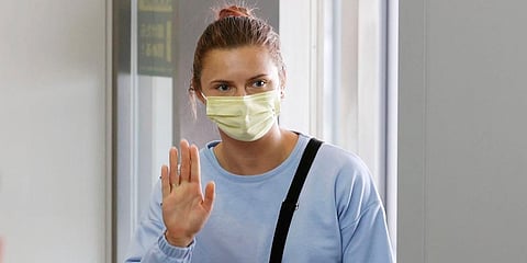 Belarusian Olympic sprinter Krystsina Tsimanouskaya waves as she leaves Narita International Airport in Narita, east of Tokyo. (Photo | AP)