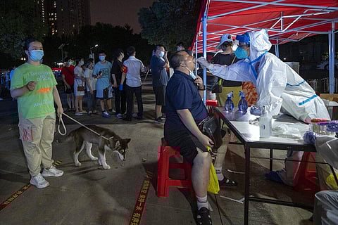 Residents line up for Covid-19 tests in Wuhan in central China's Hubei province. (Photo | AP)