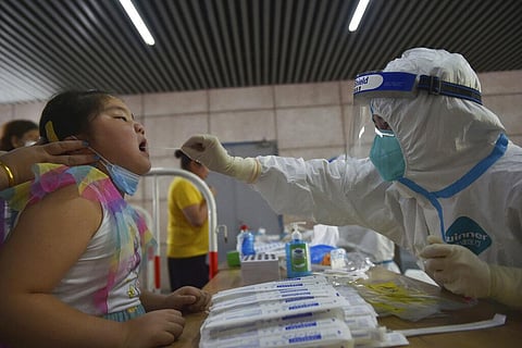 A nurse takes throat swab samples in new round of COVID-19 testing in Nanjing city in eastern China's Jiangsu province Monday, Aug. 2, 2021. (Photo | AP)