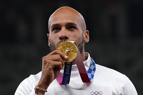 Lamont Marcell Jacobs, of Italy poses with his gold medal following the men's 100-meters final at the 2020 Summer Olympics. (Photo | AP)
