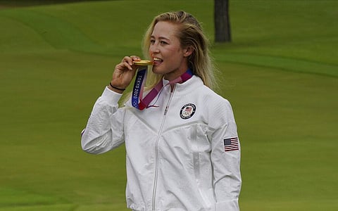 Nelly Korda, of the United States, bites her gold medal, won in the women's golf event at the 2020 Summer Olympics. (Photo | AP)