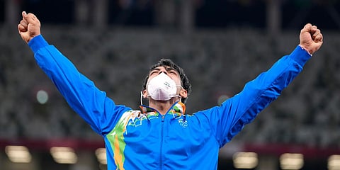 Gold medalist Neeraj Chopra reacts as he stands on the podium for the medal ceremony for the men's javelin throw at the 2020 Olympics. (Photo| AP)