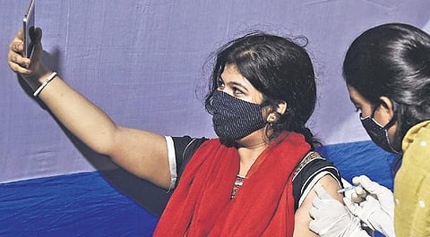 A beneficiary takes a selfie while receiving Covid-19 vaccine in Kolkata. (Photo | PTI)