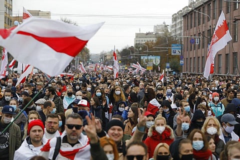 People with old Belarusian national flags march during an opposition rally to protest the official presidential election results in Minsk, Belarus. (File photo | AP)