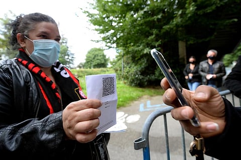 A staff member flashes a QR code of a suporter's Covid-19 health pass before start of L1 football at The Roazhon Park Stadium in Rennes, France on August 8, 2021. (Photo | AFP)