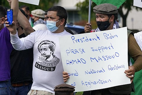 A person holds a sign asking U.S. President Joe Biden to support Ahmad Massoud, the founder of the National Resistance Front of Afghanistan. (Photo | AP)