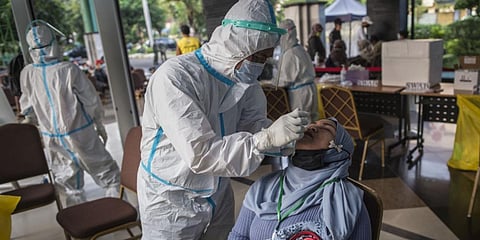 Health officials conduct Covid-19 screening on migrant workers who arrived back from Malaysia and Singapore in Surabaya. (File photo| AFP)