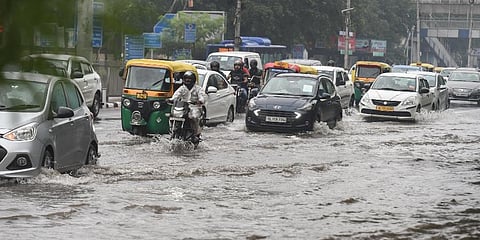 Commuters wade through a waterlogged area following heavy rains in New Delhi. (Photo | PTI)