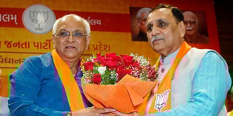 Former Gujarat Chief Minister Vijay Rupani felicitates the new Chief Minister Bhupendra Patel. (Photo | ANI)