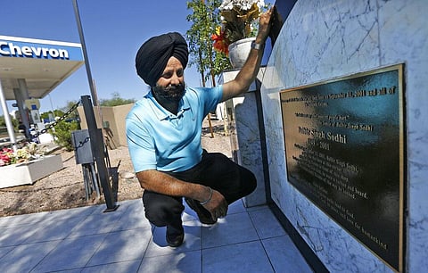 In this Aug. 19, 2016 file photo, Rana Singh Sodhi, kneels near his service station in Mesa, Ariz., next to a memorial for his brother, Balbir Singh Sodhi. (Photo | AP)