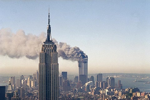 The twin towers of the World Trade Center burn behind the Empire State Building. (Photo | AP)