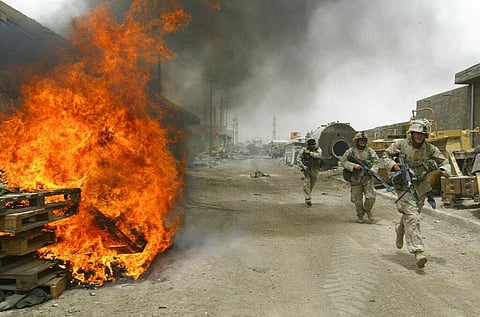 In this April 30, 2004, file photo, U.S. Marines burn their fortifications on front line positions in Fallujah, Iraq, before pulling out of the city. (Photo | AP)
