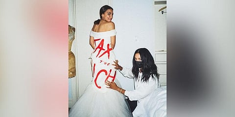 Designer Aurora James of Brother Vellies posing with her design for Congresswoman Alexandria Ocasio-Cortez for her debut appearance in the Met Gala. (Photo | Twitter/@AOC)