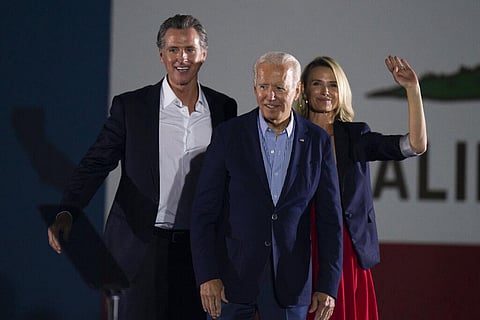 President Joe Biden, center, smiles to the crowd as he is flanked by California Gov. Gavin Newsom, and wife, Jennifer Siebel Newsom. (Photo | AP)