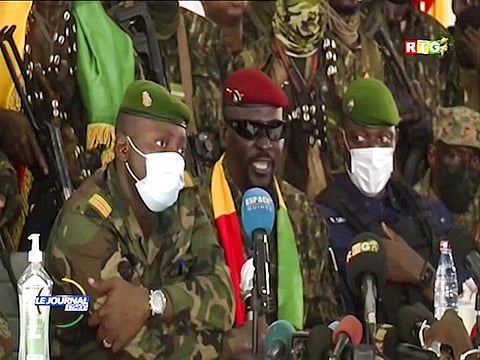 In this image made from video, Junta leader Col. Mamady Doumbouya, center, wearing a red beret and sunglasses, addresses officials in the capital Conakry, Guinea. (Photo | AP)