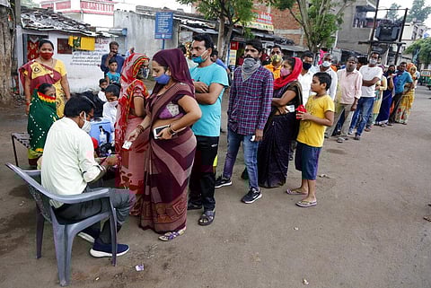 People stand in a queue to receive the vaccine for COVID-19 during a vaccination drive in Ahmedabad. (Photo | AP)
