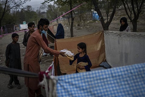 Displaced Afghans distribute food donations at an internally displaced persons camp in Kabul, Afghanistan. (Photo | AP)
