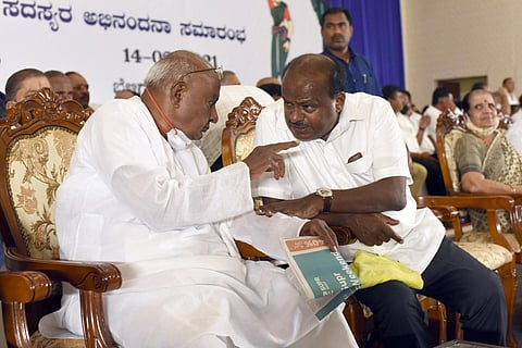 JDS supremo H D Deve Gowda in conversation with Union Minister H D Kumaraswamy at the party’s convention in Bengaluru.