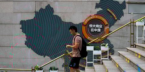 A man walks by a map showing Evergrande development projects in China, at an Evergrande city plaza in Beijing, Wednesday, Sept. 15, 2021. (Photo | AP)