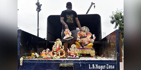 A GHMC official seizes PoP Ganesh idols that were brought to Saroornagar for immersion. (Photo | Vinay Madapu, EPS)