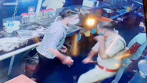 A grab of CCTV footage of additional sub-inspector Sebastian P J beating Sahir in Sea Park restaurant at Thrikannad near Bekal Tuesday night. (Photo | Special Arrangement)