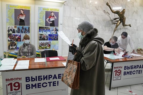 woman prepares to cast her ballot at a polling station during a parliamentary elections in Moscow, Russia, Friday, Sept. 17, 2021. (Photo | AP)