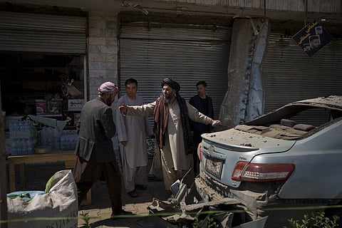 Taliban fighters and residents gather at the site of an explosion in Kabul. (Photo | AP)