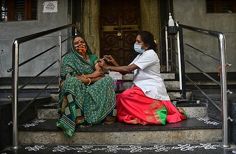 A health worker administers vaccine  at camp in a temple in Bengaluru. (Photo | Ashishkrishna HP, EPS)