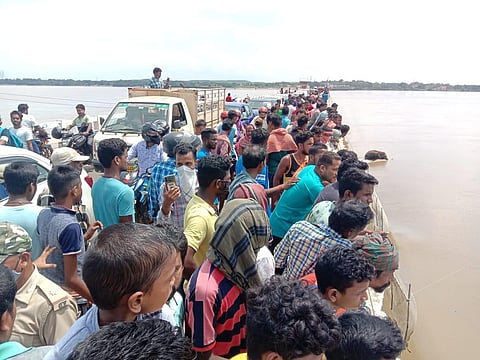 A crowd gathered on the bridge after the elephant (seen in the background) was trapped in the river (Photo | Express)
