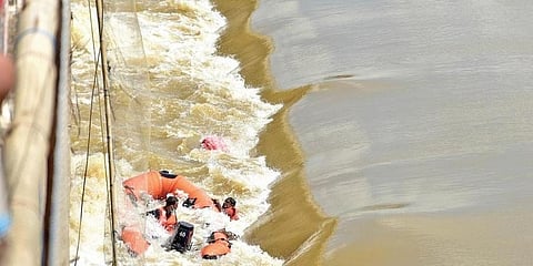 Crew members clinging to the capsized rescue boat as the elephant stands nearby in Mahanadi river at Mundali barrage near Cuttack on Friday (Photo | EPS)