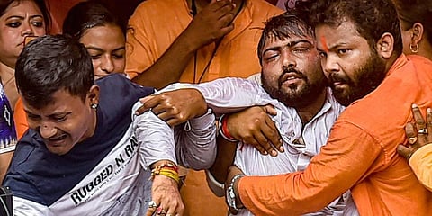 An injured BJP worker being carried after being beaten by alleged TMC workers. (Photo | PTI)