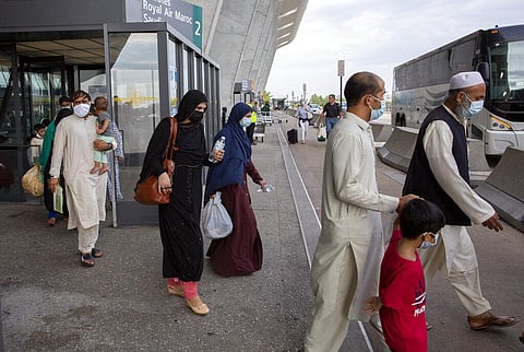 Families evacuated from Kabul, Afghanistan, walk to board a bus after they arrived at Washington Dulles International Airport (File Photo | AP)