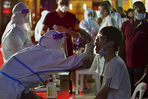 A health worker collects swab sample from a resident during a mass COVID-19 test in Putian in southeast China's Fujian province. (File Photo | AP)