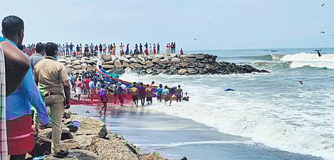 Onlookers watch the rescue operations at Azheekal beach in Kollam on Thursday | Express
