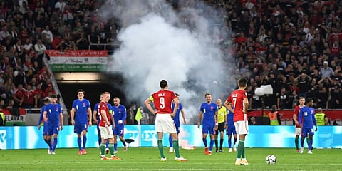 Players wait after a flare was thrown on the field after the third goal England scored, during the World Cup 2022 group I qualifying soccer match at the Puskas Ferenc Arena, in Budapest. (Photo | AP)