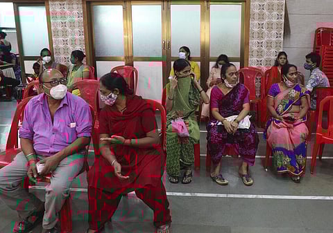 People wait to receive the vaccine for COVID-19 at a vaccination center in Mumbai. (Photo | AP)