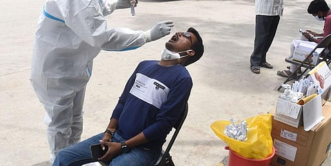 A healthcare worker collects swab sample for COVID test. (Photo | EPS)