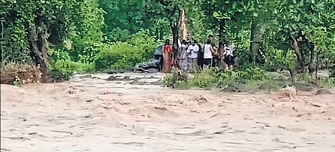 Tourists wait for help after the local river began overflowing due to incessant rains