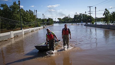 US Geological Survey workers push a boat as they look for residents on a flooded street along the Raritan River in Somerville. (Photo | AP)