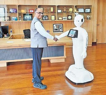 IIIT Dharwad Director Prof Kavi Mahesh with the Mitra robot. (Photo | Express)
