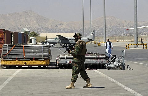 A Taliban soldier walks on the tarmac at Hamid Karzai International Airport in Kabul. (File photo| AP)