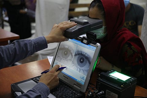 An employee scans the eyes of a woman for biometric data needed to apply for a passport, at the passport office in Kabul (Photo | AP)