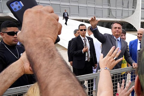 Brazilian President Jair Bolsonaro waves to supporters outside Planalto presidential palace in Brasilia (Photo | AP)