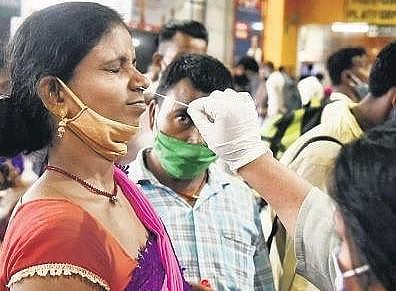 A healthcare worker collects swab sample from a woman for Covid testing. (File Photo | EPS/Parveen Negi)