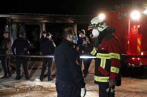 Firemen talk to each other standing near the burned out makeshift hospital in North Macedonia's western city of Tetovo, early Thursday, Sept. 9, 2021. (Photo | AP)